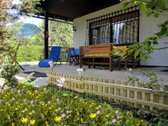 sonnige Terrasse mit Liegestühle, Sonnenschirm etc.